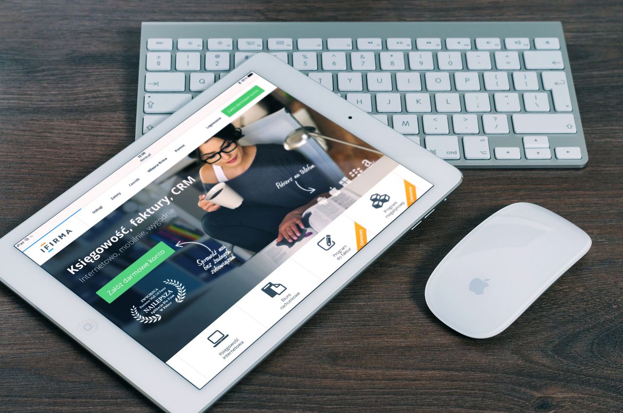 Tablet s otvorenom financijskom web stranicom, uz bijelu tipkovnicu i miš. Idealno za stock fotografije s tehnološkom temom.